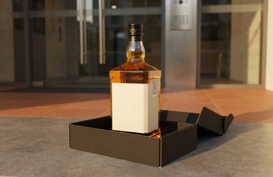 Sealed premium whisky bottle in a delivery box on a Kuala Lumpur doorstep, legal alcohol delivery in Malaysia