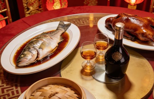 Cantonese banquet table with roast duck, steamed fish and glasses of cognac on a lazy Susan